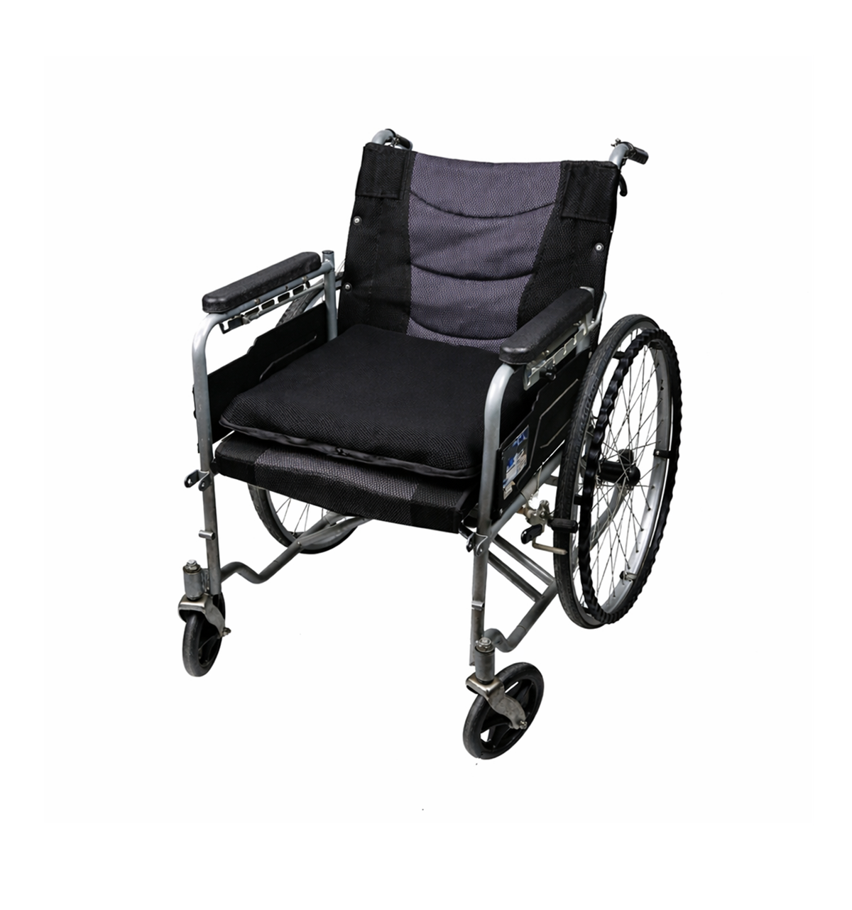 A full view of a manual wheelchair with an AJ air cushion placed on the seat for pressure relief.
