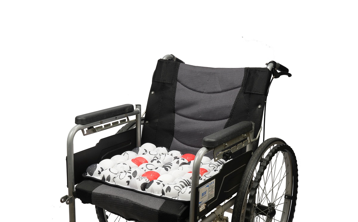 Red and white heart doodle medical air cushion on a wheelchair for decubitus ulcer prevention.