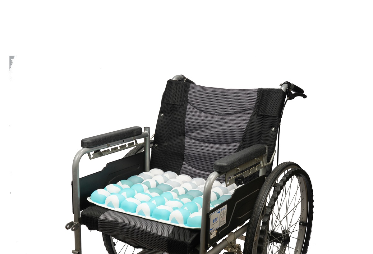 Medical-grade 3D air cell seat cushion with blue wavy pattern installed on a wheelchair for pressure relief.